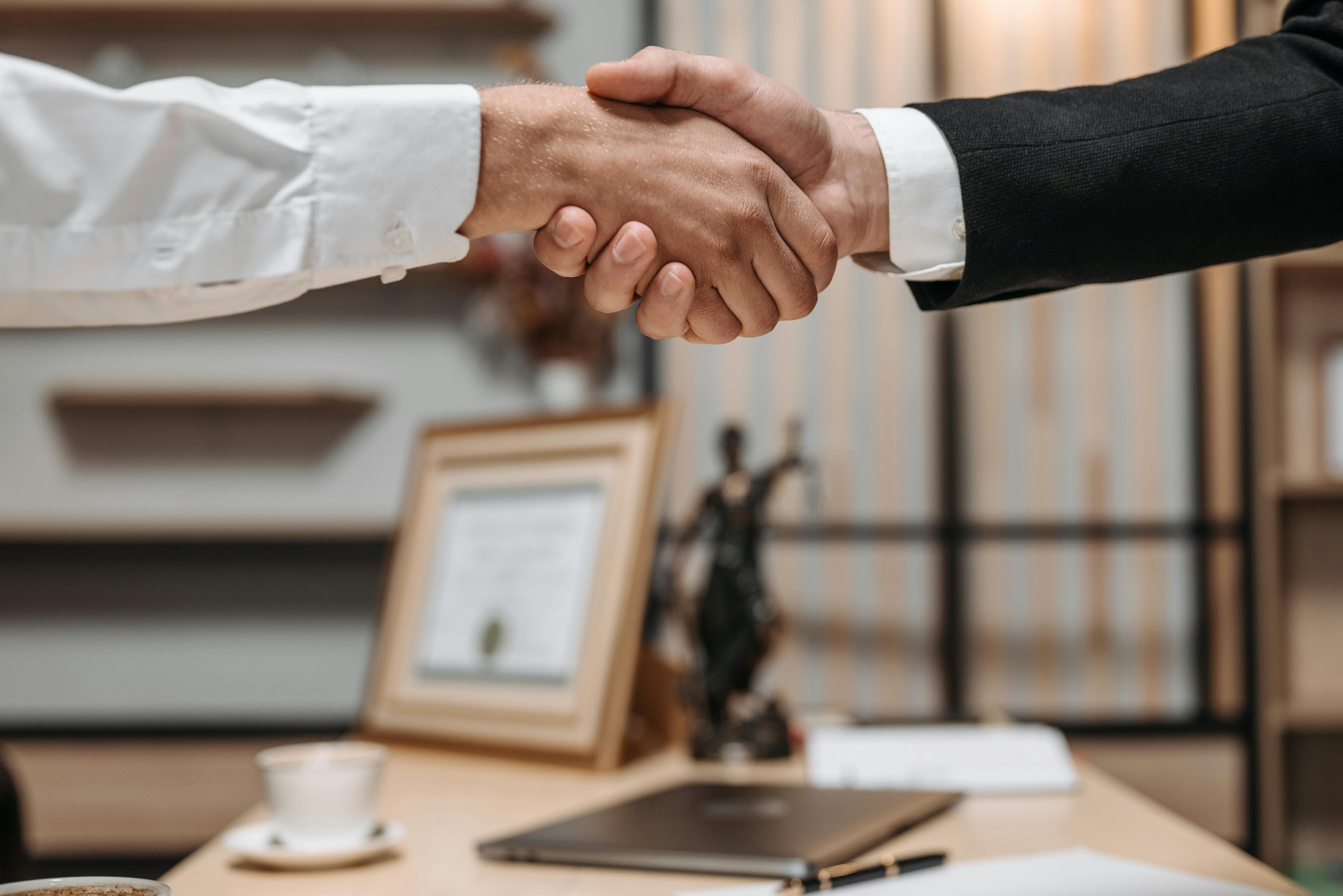 A business owner confidently shaking hands with an IT professional - it maintenance for businesses